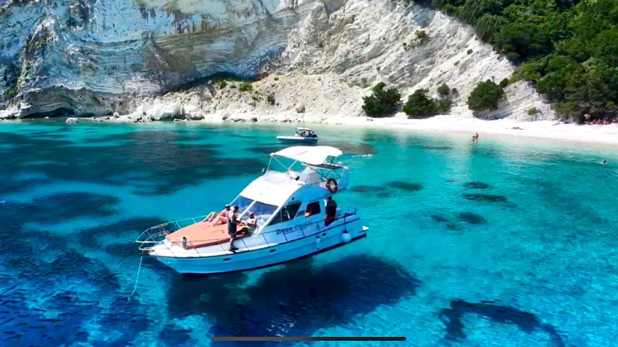 Cruise boat anchored in a turquoise Ionian bay